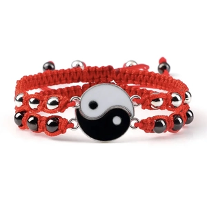 Macro detail of red woven Yin Yang bracelet with magnetic clasp and metal accents