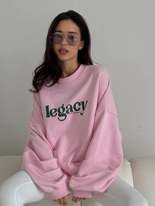 Pink oversized crewneck sweatshirt with legacy lettering for a street fashion aesthetic