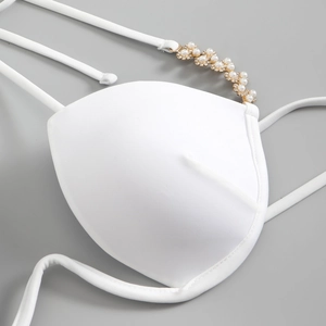Detail of white bikini cup with gold hardware, pearls and sparkling rhinestones