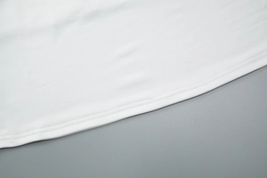 Close-up of high-quality stitching and hem detail on the white knitted dress bottom