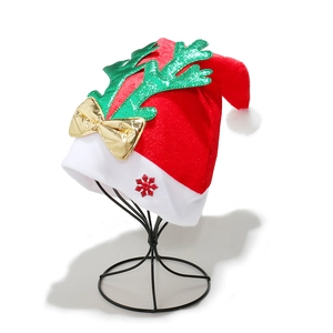 Christmas hat with green glitter reindeer antlers and gold bow on a display stand