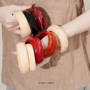 Chunky acrylic bangles with geometric facets in solid red, cream and black tones