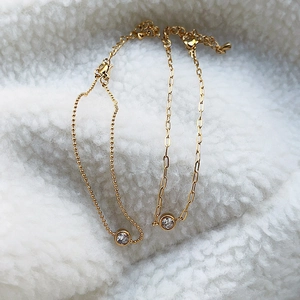 Detail of 18k gold plated paperclip and ball chains with round zircon insets