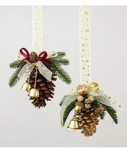 Close-up of Christmas pine cone ornaments with gold bells and velvet ribbons