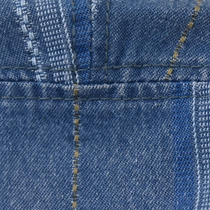 Macro detail of blue denim fabric texture and reinforced double-row stitching on the hat