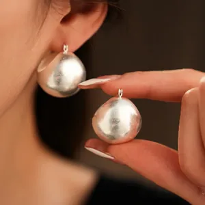 Minimalist silver matte brushed metal ball stud earrings shown on model
