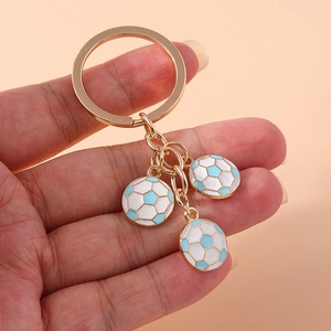 Golden keychain with three mini football pendants in white and light blue enamel finish