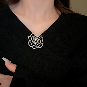 Macro detail of a silver rose flower brooch featuring sparkling zircon and hollow design