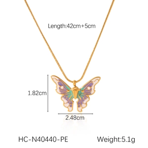 Detail shot of purple and white enamel butterfly pendant on gold snake chain necklace