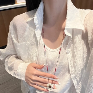 French vintage pearl flower pendant necklace with red beaded cord shown on a model