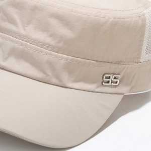 Detailed macro view of khaki flat top cap with metal 95 badge and breathable mesh back