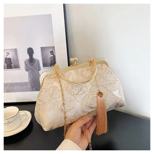 Detailed view of champagne vintage shell bag with peony embroidery and golden tassel