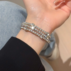 Close-up of a silver multi-layer rhinestone bracelet worn on a female wrist