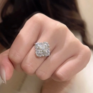 Detailed view of silver flower ring with white pearls and diamonds on model finger