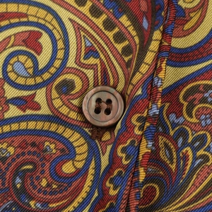 Detailed close-up of paisley print fabric with a vintage dark brown wooden button
