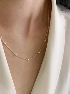 Dettaglio di una collana minimalista in argento sterling S925 sul collo di una modella