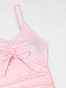 Detail shot of pink eyelet swimsuit fabric with drawstring ties and cutout design
