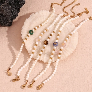 Detail view of pearl beads bracelets with natural stone hexagons and gold star charms