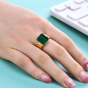 Detail of a square green shell stone set in a golden stainless steel watchband ring