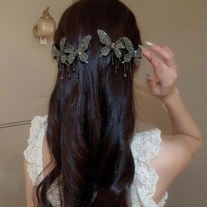 Detail shot of sparkling rhinestone butterfly hair clip with elegant fringe on model
