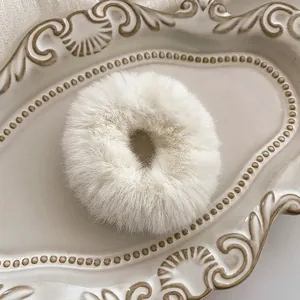 Close-up of white plush scrunchie showing the soft texture and 4cm inner diameter