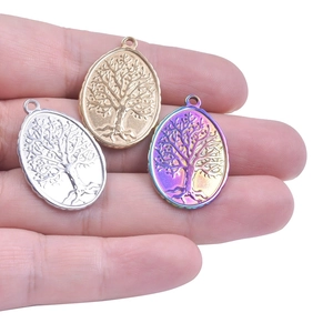 Detail showing oval tree of life pendants in gold, silver and rainbow stainless steel