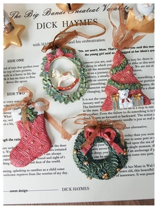 Detailed view of four vintage Christmas resin ornaments with festive tree and wreath designs