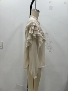 Detail shot of multi-layered ruffles on sleeve of beige chiffon blouse for women