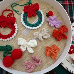 Close-up of handmade crochet Christmas wreaths and colorful bows in a tray