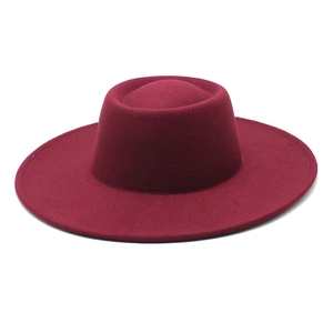 Detail view of the burgundy flat top felt hat with distinct crown indentation style