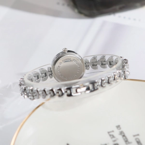Detail view of the stainless steel case back of a luxury silver mermaid watch for women