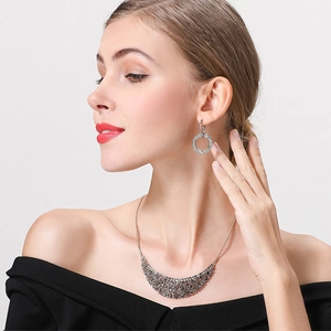 Close-up of elegant silver necklace and hoop earrings with sparkling rhinestones on model