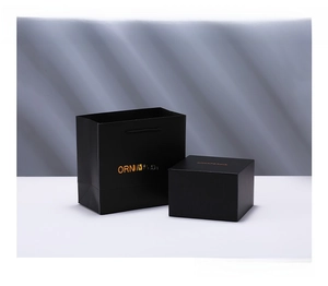 Detailed view of matte black luxury gift box and paper bag with gold foil branding