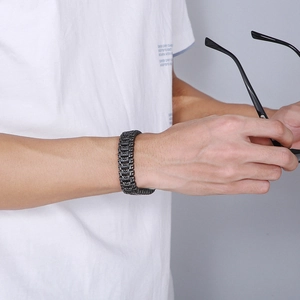 Close-up of black titanium Tree of Life bracelet on male wrist with a white T-shirt