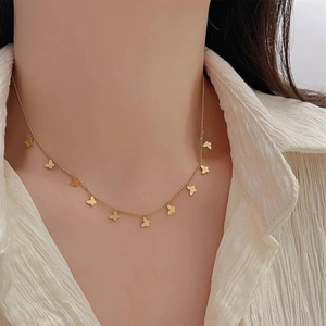 Elegant gold butterfly choker necklace worn by model against a white textured background