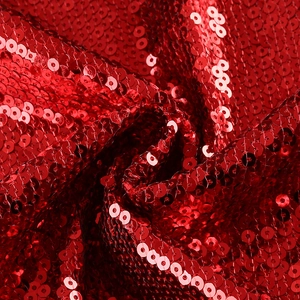 Detailed macro shot of high-quality red circular sequins on soft fabric for party outfits