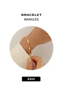 Close-up of golden minimalist open cuff bracelet with hammered texture finish