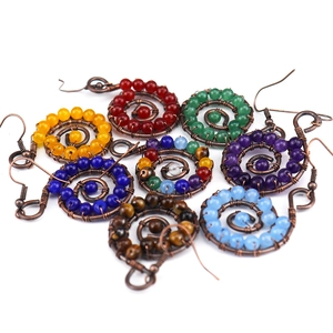 Detailed close-up of handmade wire-wrapped crystal earrings in various vibrant colors