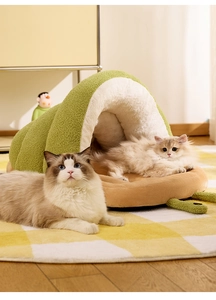 Detail view of the warm green snail shaped plush cat bed with cats in a cozy setting