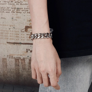 Close-up of a silver stainless steel Cuban link bracelet worn on a man wrist