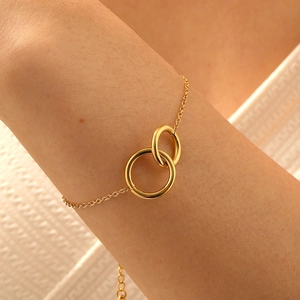 Minimalist gold-plated stainless steel bracelet with interlocking circles on wrist