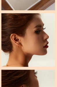 Polished gold heart drop earrings and matching thin chain necklace on female model
