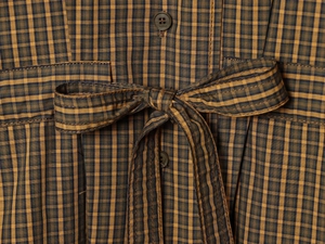 Close-up of brown plaid shirt featuring waist bow-tie detail and grey button texture