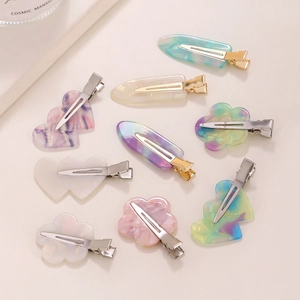 Detailed flat lay of colorful floral and heart-shaped acetate hair clips with metal bases