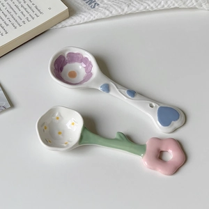 Detail of flower-shaped ceramic spoons with colorful floral patterns and green stem handles