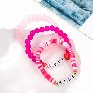 Detailed macro of pink and red LOVE and KISS beaded bracelets set for Valentine's Day gift