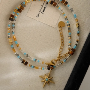Bohemian stainless steel beaded necklace with tiger eye stones and a gold star pendant