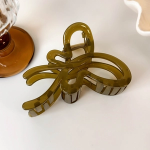 Macro view of olive green jelly butterfly hair claw with translucent finish and gold spring