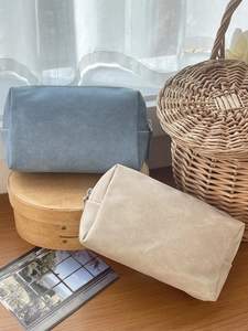 Detail view of square waterproof PU makeup bags in grey-blue and beige matte texture