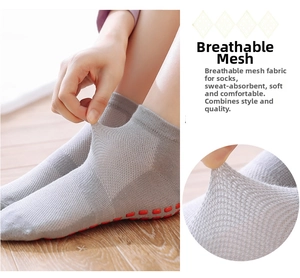 Detail of grey non-slip yoga socks featuring breathable mesh and red anti-skid grip soles